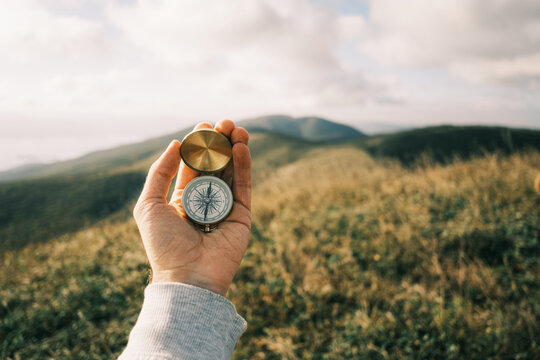 Travel concept. Vintage compass in hands in the mountains.