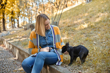 Naklejka na ściany i meble Closeup on happy young woman with dog outdoors in autumn