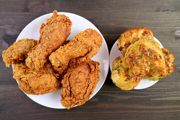 Plate of Mouthwatering Crispy Fried Chickens with Aromatic Herb Biscuits on Wooden Table