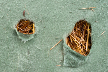 Torn green fleece with hay behind it