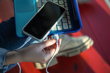 The smartphone is connected to the laptop via USB cable.