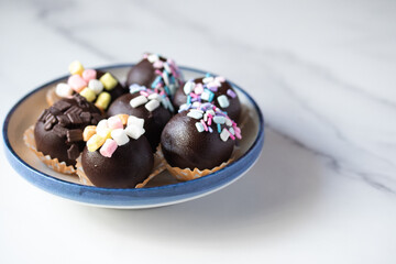 Chocolate balls sprinkled with colored sugar, cute cakes.