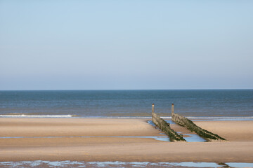 Domburg beach with wooden piles, blue sky and no people