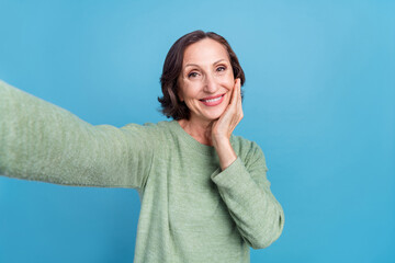 Fototapeta premium Photo of old white hair woman do selfie hand face hand wear green jumper isolated on blue color background