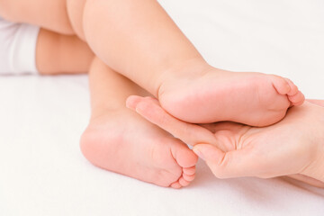 The foot of a newborn baby in the mother's palm, soft focus