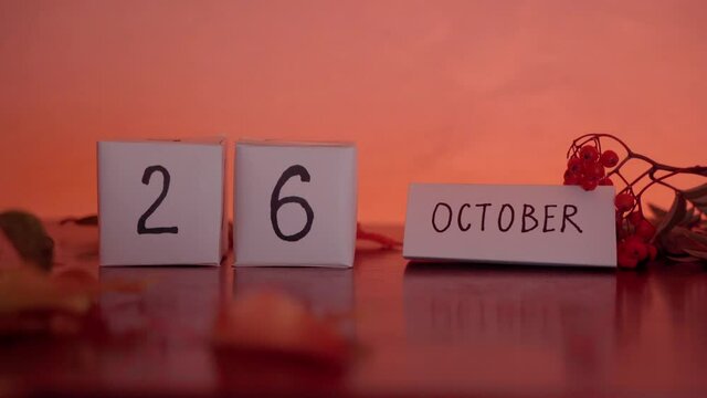 Cube calendar with an important date of October 26th with maple leaves and berries on the desk. Autumn Season. Intersex Awareness Day, National Pumpkin Day
