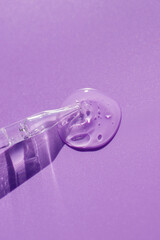 Pipette close-up on a purple background in soft focus. Beautiful shadow in the sunlight. Skincare products , natural cosmetic. Beauty concept for face and body care