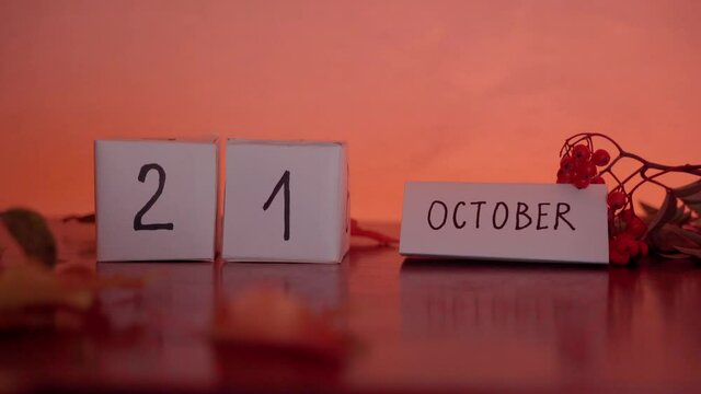 Cube calendar with an important date of October 22th with maple leaves and berries on the desk. Autumn Season. International Day of the Nacho, Police Commemoration Day
