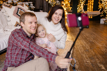 Fototapeta premium Happy Family celebrate Christmas online. video call for the new year greeting. Decorated house for christmas eve. Selfie Remote communication. Lifestyle live funny photo. Togetherness. 