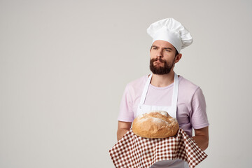 bearded man in white apron cooking food