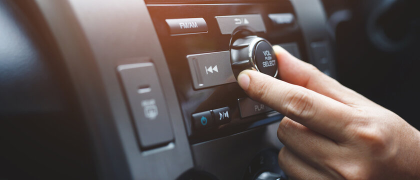 close up hand open car radio listening. Car Driver changing turning button Radio Stations on His Vehicle Multimedia System. Modern touch screen Audio stereo System. transportation and vehicle concept
