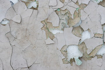 Peeling paint on the wall. Old concrete wall with cracked flaking paint. Weathered rough painted...