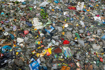 The mouth of the canal is blocked by piles of plastic waste and food waste dumped in the city of...