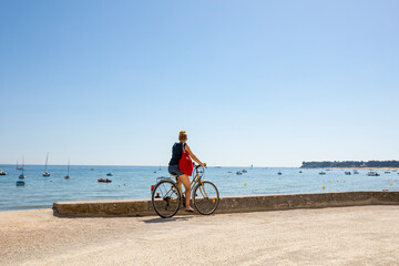 Balade en bord de mer à vélo, femme devant le littoral français.