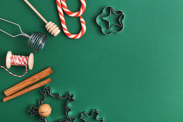 Green background with holiday decoration and baking utensils. Top view, empty space.