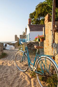 Vieux vélo bleu en bord de plage.