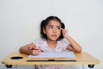 Asian little girl showing thinking gesture during study