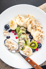 oatmeal breakfast bowl fruit vegetable milk, gluten free, lactose free, banana, kiwi, berrie, blueberrie meal snack on the table copy space food background rustic 