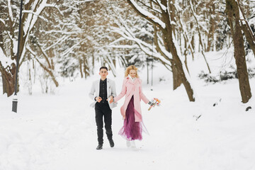 Fototapeta na wymiar Amazing bride and groom walking in the winter in the Park. Winter wedding.