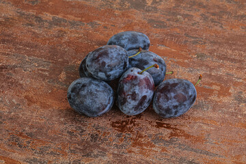 Ripe plum heap over background