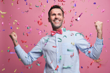 Studio shot of successful middle aged man celebrating achievement