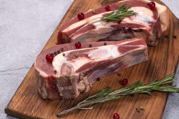 Several pieces of fresh raw beef brisket on the bone with rosemary