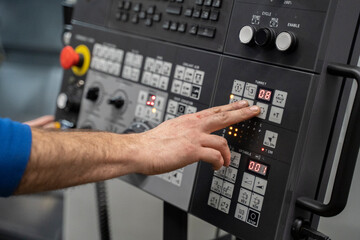 man using the controls of a CNC Lathe