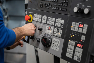 man using the controls of a CNC Lathe