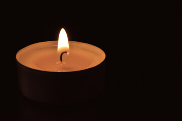 Tea light candle in the dark.