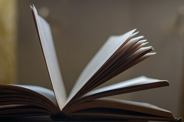 A defocused shot of an old open book. Dusty pages of a hardcover