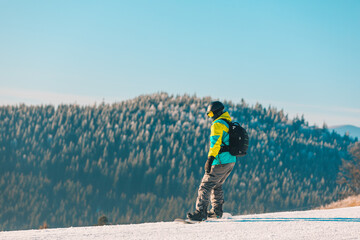 man snowboarding down by hill mountains on background