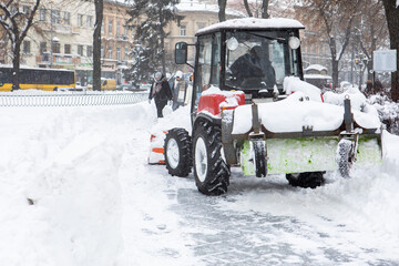 tractor is cleaning city streets after snow storm