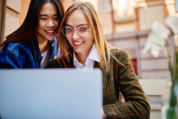 Positive women watching video on laptop