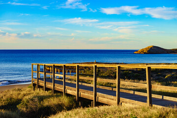 Fototapeta na wymiar Beach with wooden path to sea water.