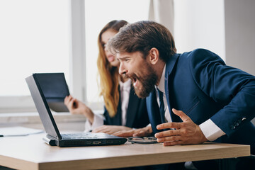 business man and woman sitting in front of a laptop teamwork professionals