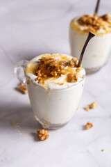 Cups of yogurt with honey and nuts on white background