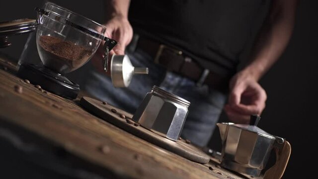 Preparation of delicious black coffee Italian moka. Geyser coffee maker on a wooden table on a dark background.