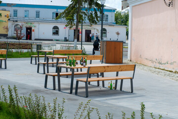 Empty beer bottles on a table in the city square on a summer Sunday morning