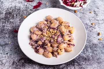 Vegan potato gnocchi with walnut and radicchio sauce.