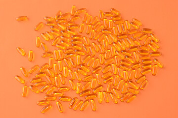 Fish oil, Omega-3. Healthy vitamins or medicines in soft transparent capsules on an orange background. healthy product concept, Vitamin A, Vitamin D3, Omega 6