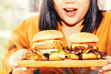 Concept of a large-scale woman : Hungry woman eats a large amount of marinated beef hamburgers....