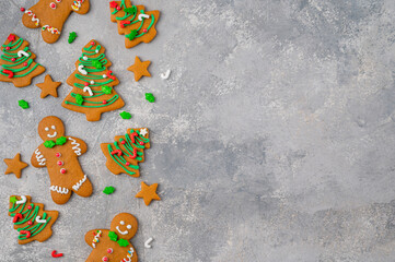 Christmas or New Year food background. Gingerbread cookies decorated with sugar glaze on a gray...