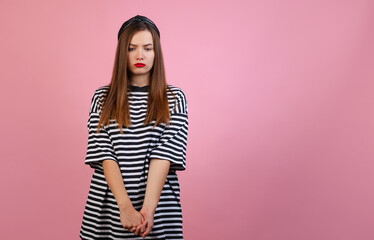 Obraz premium Portrait of young beautiful girl with long silk hair standing isolated on light pink studio background. Concept of emotions, fashion