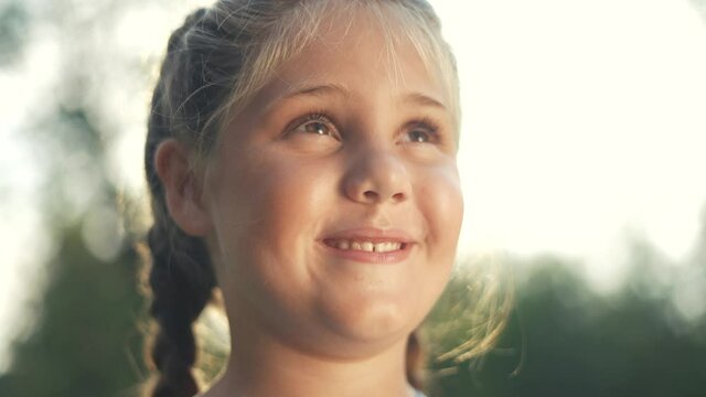 portrait of a little girl in nature smiling in the park. happy family kid dream concept. daughter with chubby cheeks cheerful smiling in the park. little girl close-up. family happy concept childhood