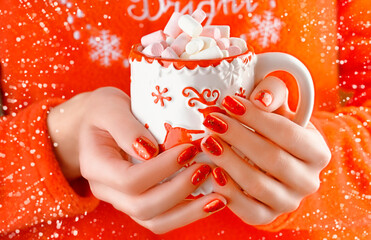 Female hands holding a Christmas cup with cocoa and marshmallows. Christmas mood.Red festive manicure.