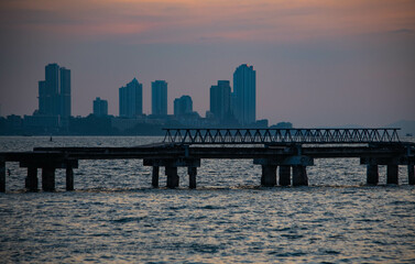 Abandoned bridge in the middle of the sea during sunset at Chittaphawan Temple, Chonburi Province, Thailand