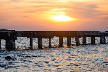 Fototapeta na wymiar Abandoned bridge in the middle of the sea during sunset at Chittaphawan Temple, Chonburi Province, Thailand