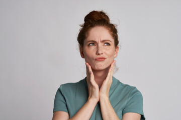 Beautiful uncertain redhead woman at the studio - obrazy, fototapety, plakaty