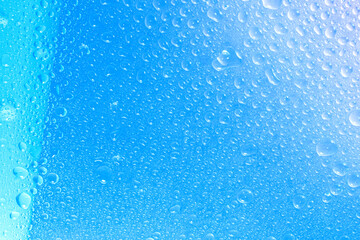 Water droplets in the glass, air bubbles and cold water droplets fall on the glass bottle and in the glass.