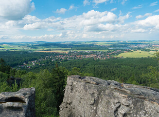 Fototapeta na wymiar View from hill Topfer sandstone viewpoint near Oybin with view of Zittau town at Poland German borders in Zittauer Gebirge mountains, Saxony, germany. Summer sunny day, blue sky, white clouds